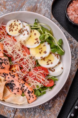 Somon, marul, domates, yumurta, tuz ve baharatlı leziz taze sezar salatası.