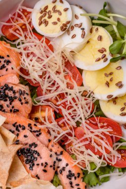 Somon, marul, domates, yumurta, tuz ve baharatlı leziz taze sezar salatası.
