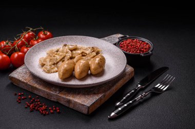 Fish or meat quenelles with delicate mushroom sauce, salt and spices on a dark concrete background clipart