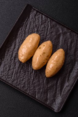 Hassas mantar soslu balık ya da et quenelles, koyu beton arka planda tuz ve baharatlar