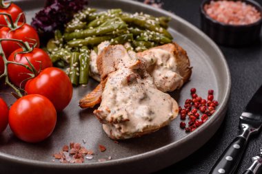 Asya yemeği pişirilmiş yeşil fasulyeli tavuk göğsü, susam tohumu ve koyu beton arka planda sos.