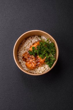 Asya yemekleri tatlı ve ekşi soslu haşlanmış pirinç, koyu beton arka planda baharatlar ve otlar.