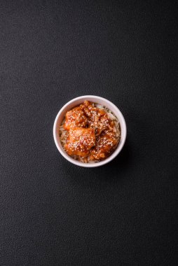 Asya yemekleri tatlı ve ekşi soslu haşlanmış pirinç, koyu beton arka planda baharatlar ve otlar.