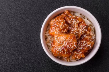 Asya yemekleri tatlı ve ekşi soslu haşlanmış pirinç, koyu beton arka planda baharatlar ve otlar.