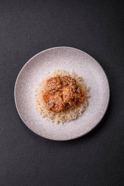 Asya yemekleri tatlı ve ekşi soslu haşlanmış pirinç, koyu beton arka planda baharatlar ve otlar.