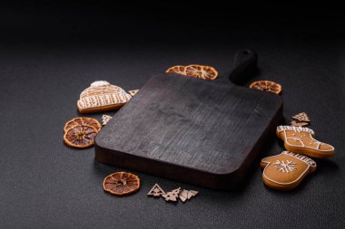 Boş ahşap kesme tahtası, fotokopi alanı, zencefilli kurabiyeler ve koyu desenli Noel dekoru.