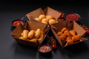 Fast food patates kızartması, peynir kızartması, peynir topları, peynir çubukları ve tavuklu nugget.