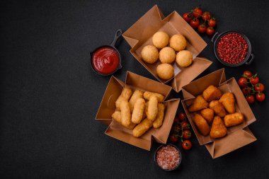 Fast food patates kızartması, peynir kızartması, peynir topları, peynir çubukları ve tavuklu nugget.