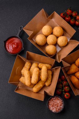 Fast food patates kızartması, peynir kızartması, peynir topları, peynir çubukları ve tavuklu nugget.
