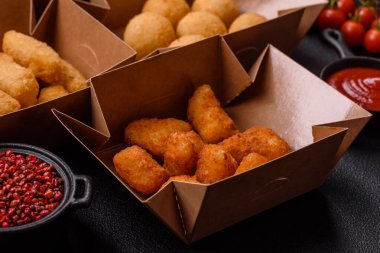 Fast food patates kızartması, peynir kızartması, peynir topları, peynir çubukları ve tavuklu nugget.