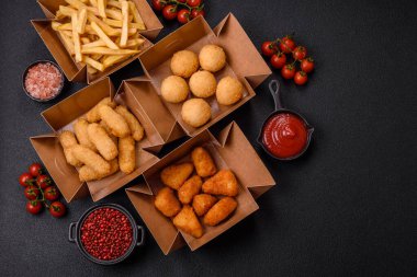 Fast food patates kızartması, peynir kızartması, peynir topları, peynir çubukları ve tavuklu nugget.