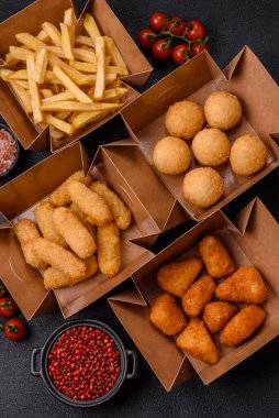 Fast food patates kızartması, peynir kızartması, peynir topları, peynir çubukları ve tavuklu nugget.