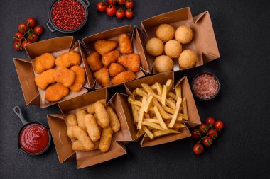 Fast food patates kızartması, peynir kızartması, peynir topları, peynir çubukları ve tavuklu nugget.