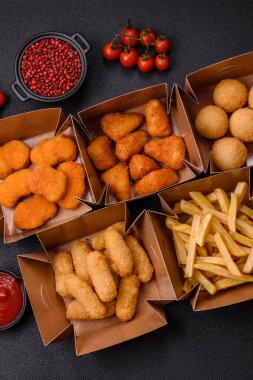 Fast food patates kızartması, peynir kızartması, peynir topları, peynir çubukları ve tavuklu nugget.