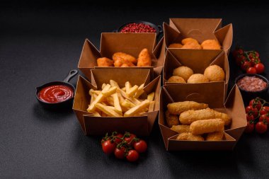 Fast food patates kızartması, peynir kızartması, peynir topları, peynir çubukları ve tavuklu nugget.