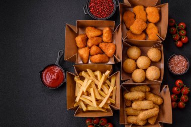 Fast food patates kızartması, peynir kızartması, peynir topları, peynir çubukları ve tavuklu nugget.