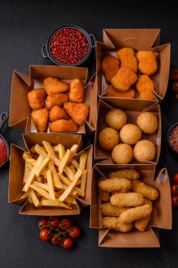 Fast food patates kızartması, peynir kızartması, peynir topları, peynir çubukları ve tavuklu nugget.
