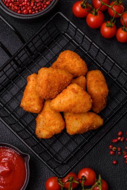 Koyu beton bir arka planda tuzlu ve baharatlı nugget şeklinde pişirilmiş peynirli krema ya da peynirli sandviç.