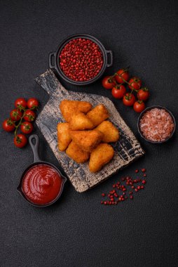 Koyu beton bir arka planda tuzlu ve baharatlı nugget şeklinde pişirilmiş peynirli krema ya da peynirli sandviç.