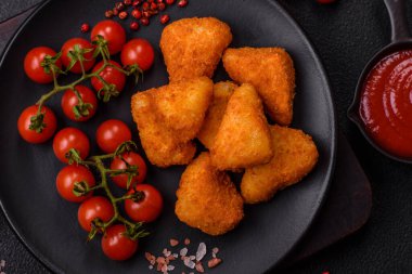 Koyu beton bir arka planda tuzlu ve baharatlı nugget şeklinde pişirilmiş peynirli krema ya da peynirli sandviç.