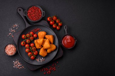 Koyu beton bir arka planda tuzlu ve baharatlı nugget şeklinde pişirilmiş peynirli krema ya da peynirli sandviç.