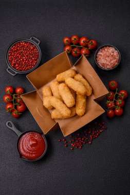 Fast food peynirli çubuklar, koyu beton arka planda tuz ve baharatlar.