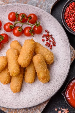 Fast food peynirli çubuklar, koyu beton arka planda tuz ve baharatlar.