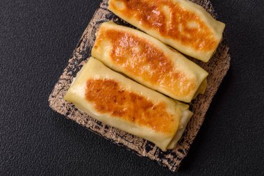 Koyu beton arka planda doyurucu bir kahvaltı için farklı dolguları olan tatlı ya da lezzetli bir krep.