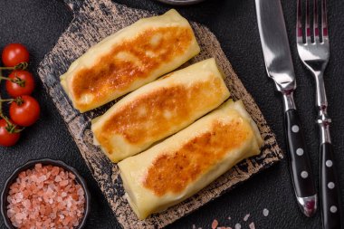 Koyu beton arka planda doyurucu bir kahvaltı için farklı dolguları olan tatlı ya da lezzetli bir krep.