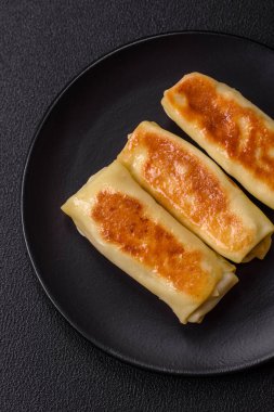 Koyu beton arka planda doyurucu bir kahvaltı için farklı dolguları olan tatlı ya da lezzetli bir krep.