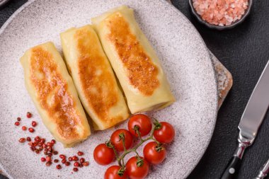 Koyu beton arka planda doyurucu bir kahvaltı için farklı dolguları olan tatlı ya da lezzetli bir krep.
