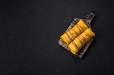 Koyu beton arka planda doyurucu bir kahvaltı için farklı dolguları olan tatlı ya da lezzetli bir krep.