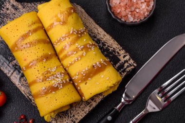 Koyu beton arka planda doyurucu bir kahvaltı için farklı dolguları olan tatlı ya da lezzetli bir krep.