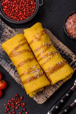 Koyu beton arka planda doyurucu bir kahvaltı için farklı dolguları olan tatlı ya da lezzetli bir krep.