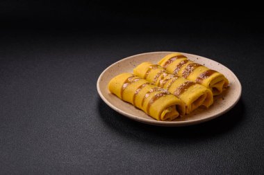 Koyu beton arka planda doyurucu bir kahvaltı için farklı dolguları olan tatlı ya da lezzetli bir krep.