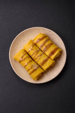 Koyu beton arka planda doyurucu bir kahvaltı için farklı dolguları olan tatlı ya da lezzetli bir krep.