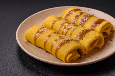 Koyu beton arka planda doyurucu bir kahvaltı için farklı dolguları olan tatlı ya da lezzetli bir krep.