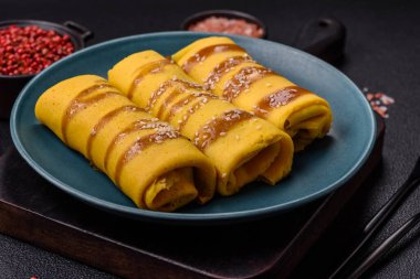 Koyu beton arka planda doyurucu bir kahvaltı için farklı dolguları olan tatlı ya da lezzetli bir krep.