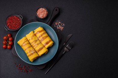 Koyu beton arka planda doyurucu bir kahvaltı için farklı dolguları olan tatlı ya da lezzetli bir krep.