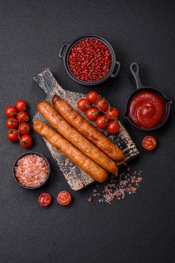 Koyu beton bir arka planda tuzlu, baharatlı ve otlu kızarmış biftek veya domuz sosisi.