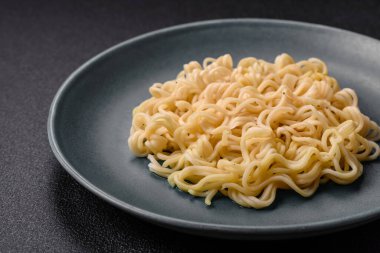 Koyu beton arka planda balık ve soslu pirinç eriştesi, tuz ve baharat.