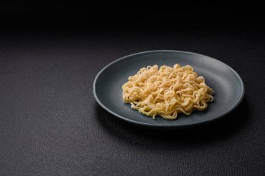 Koyu beton arka planda balık ve soslu pirinç eriştesi, tuz ve baharat.