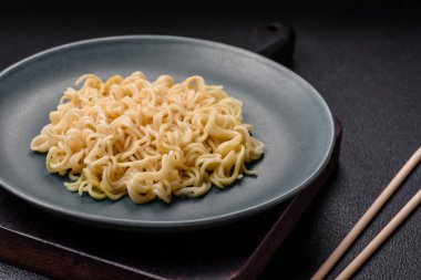 Koyu beton arka planda balık ve soslu pirinç eriştesi, tuz ve baharat.