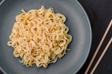 Koyu beton arka planda balık ve soslu pirinç eriştesi, tuz ve baharat.