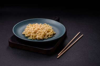 Koyu beton arka planda balık ve soslu pirinç eriştesi, tuz ve baharat.