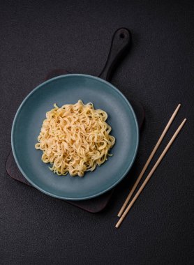 Koyu beton arka planda balık ve soslu pirinç eriştesi, tuz ve baharat.