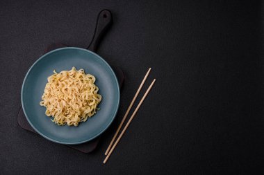 Koyu beton arka planda balık ve soslu pirinç eriştesi, tuz ve baharat.