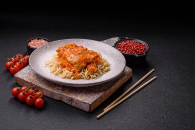 Koyu beton arka planda balık ve soslu pirinç eriştesi, tuz ve baharat.