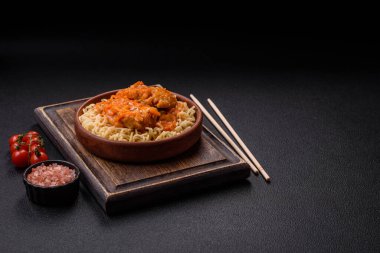 Koyu beton arka planda balık ve soslu pirinç eriştesi, tuz ve baharat.