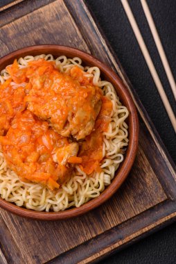 Koyu beton arka planda balık ve soslu pirinç eriştesi, tuz ve baharat.